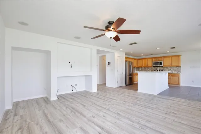 a view of a kitchen with wooden floor and a ceiling fan