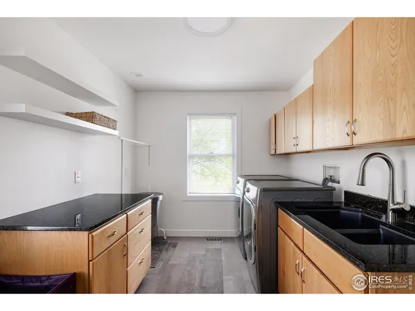 a kitchen with granite countertop a sink white cabinets and black appliances