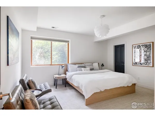 a bedroom with a bed and a large window