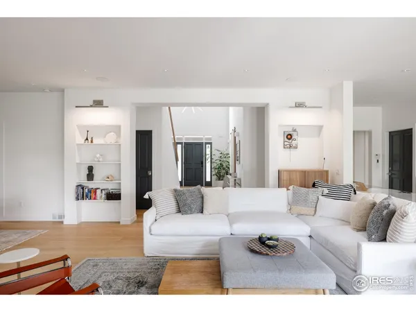 a living room with furniture white walls and a dining table