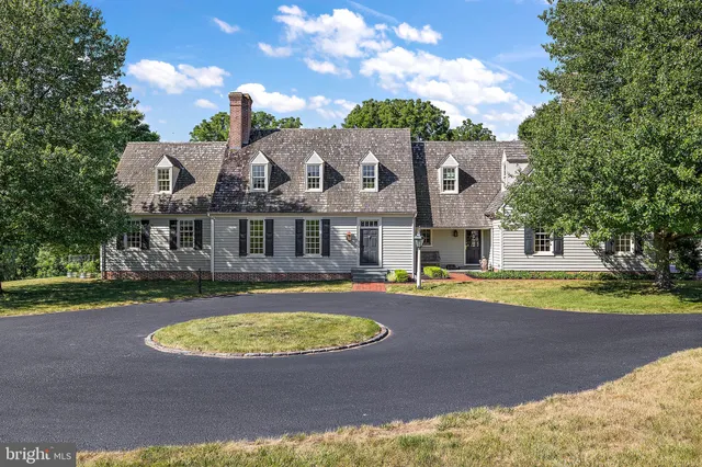 a living room with fireplace furniture and a view of kitchen
