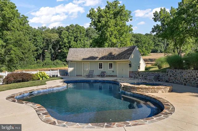 a backyard of a house with lots of plants and large trees