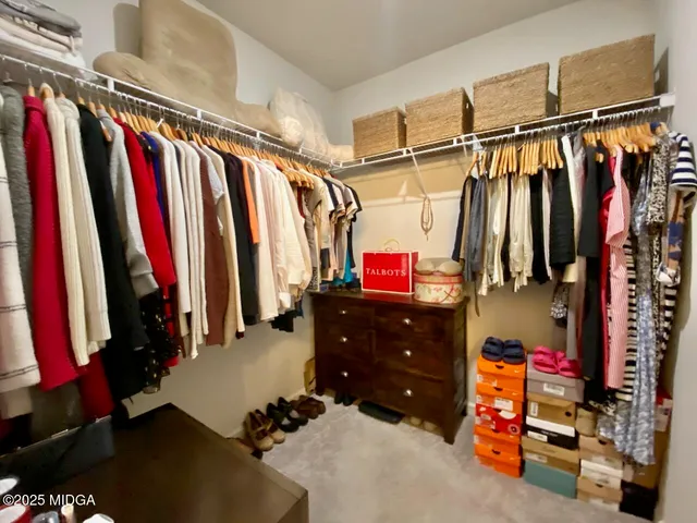 a view of walk in closet with clothes