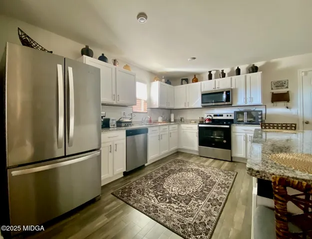 a kitchen with stainless steel appliances granite countertop a refrigerator sink and stove