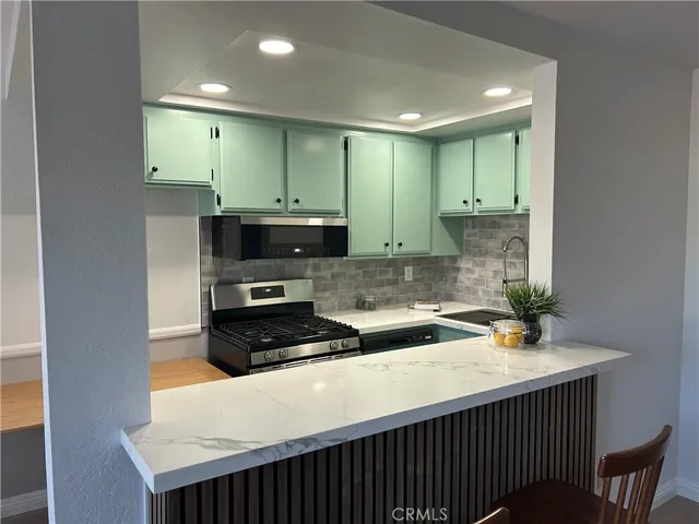 a kitchen with stainless steel appliances a sink stove and cabinets