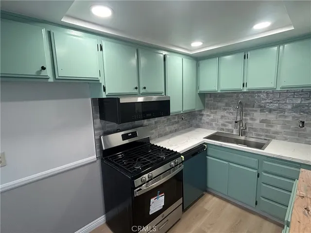 a kitchen with stainless steel appliances granite countertop a sink and a stove