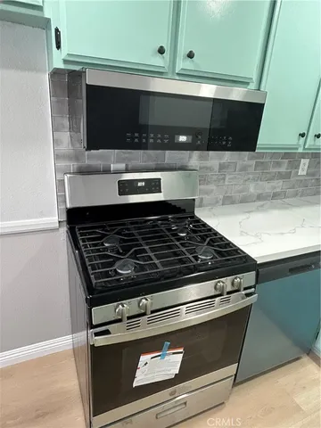 a stove top oven sitting inside of a kitchen