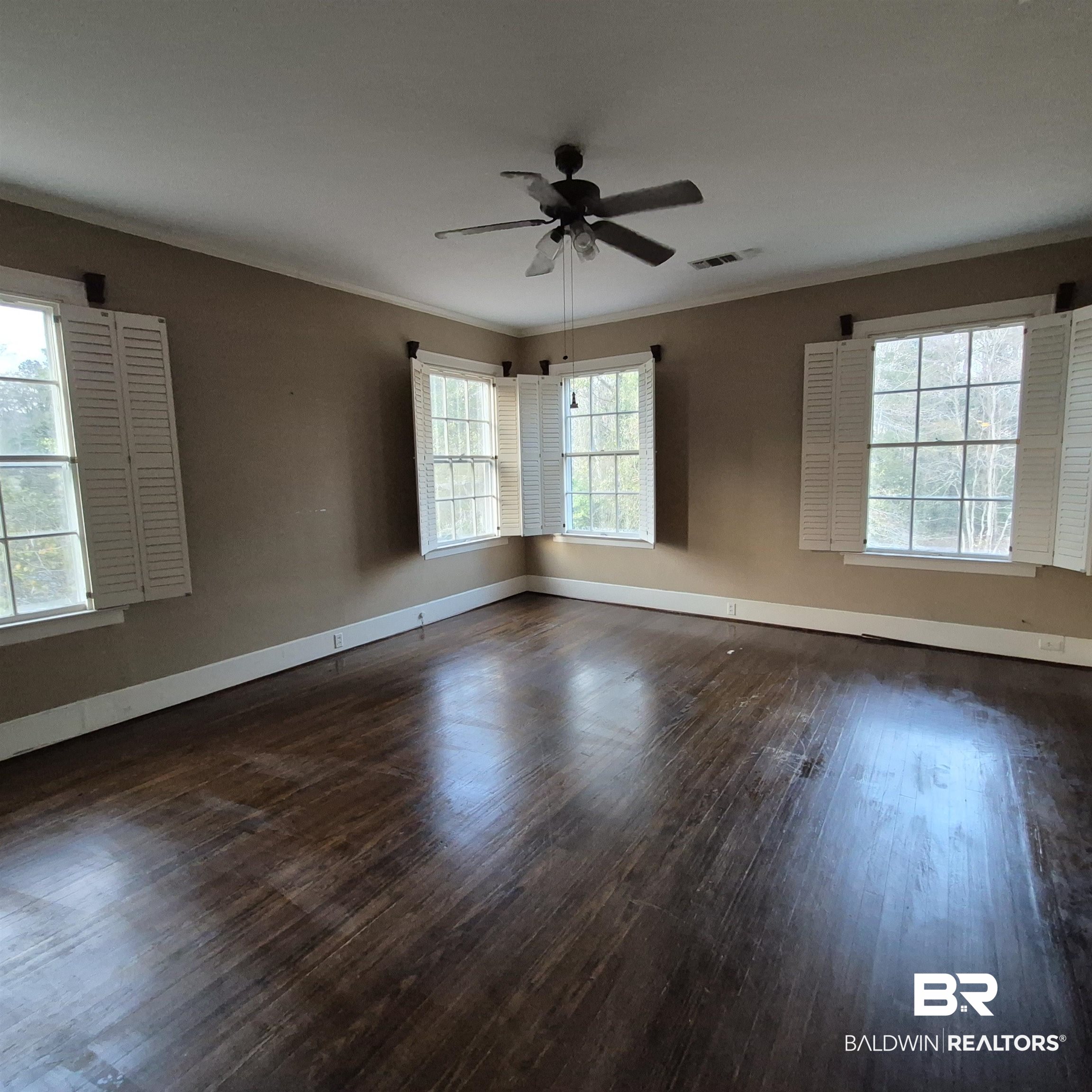 308 Rural Street Evergreen, AL 36401 - Photo 25 of 40 Unfurnished room with dark wood finished floors, a ceiling fan, and crown molding