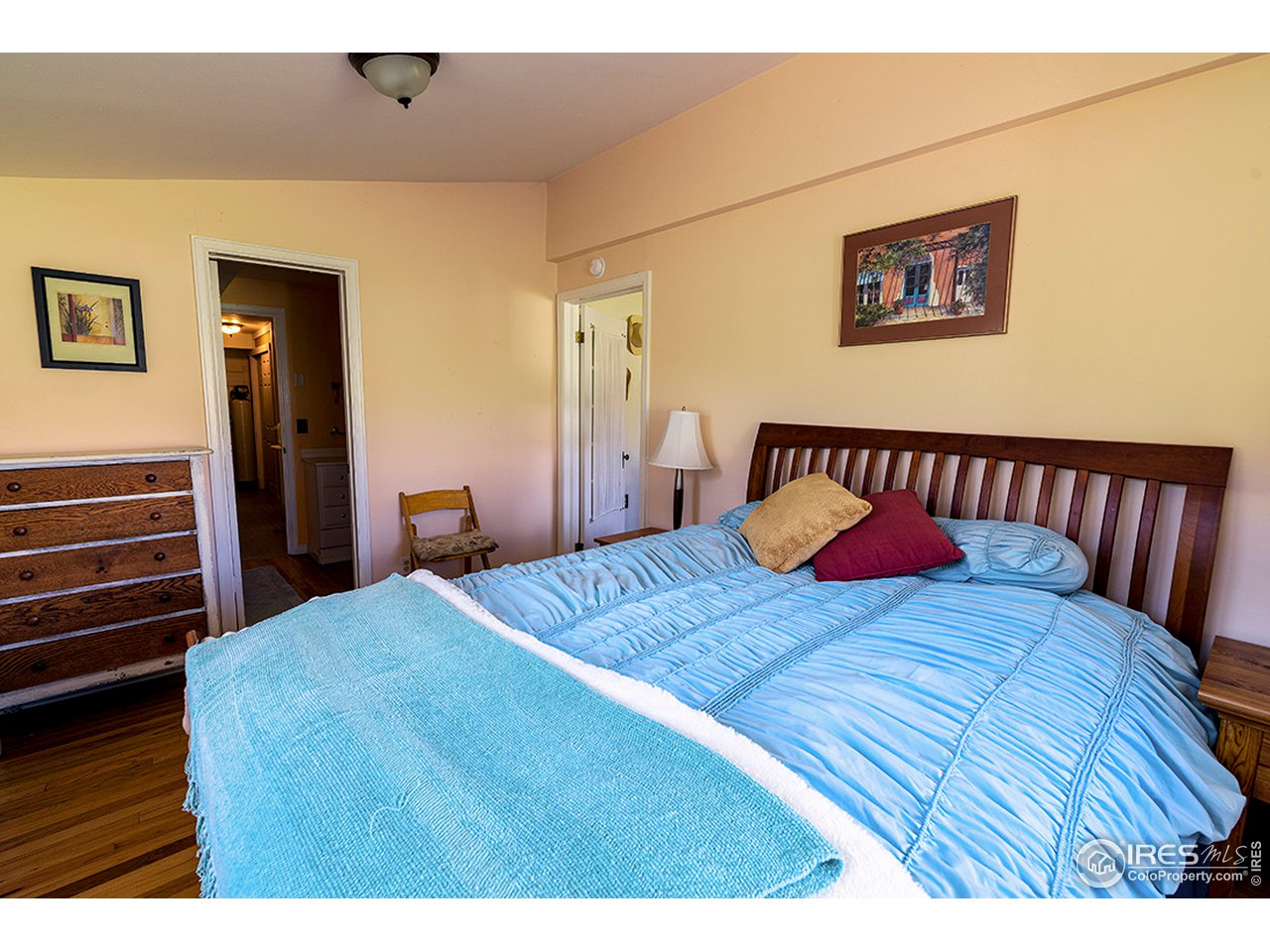222 Boxer Ranch Road Livermore, CO 80536 - Photo 13 of 28 a bedroom with a bed and wooden floor