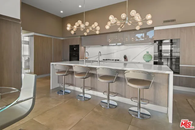 a view of a patio with couches dining table and chairs under an umbrella