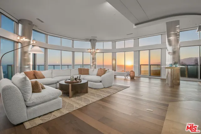 a large bedroom with a large window and a wooden floor