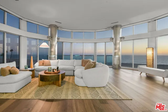 a living room with couches and a large mirror with wooden floor