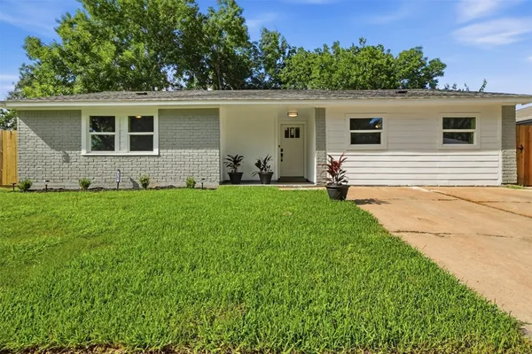 a view of a house with a yard and sitting area