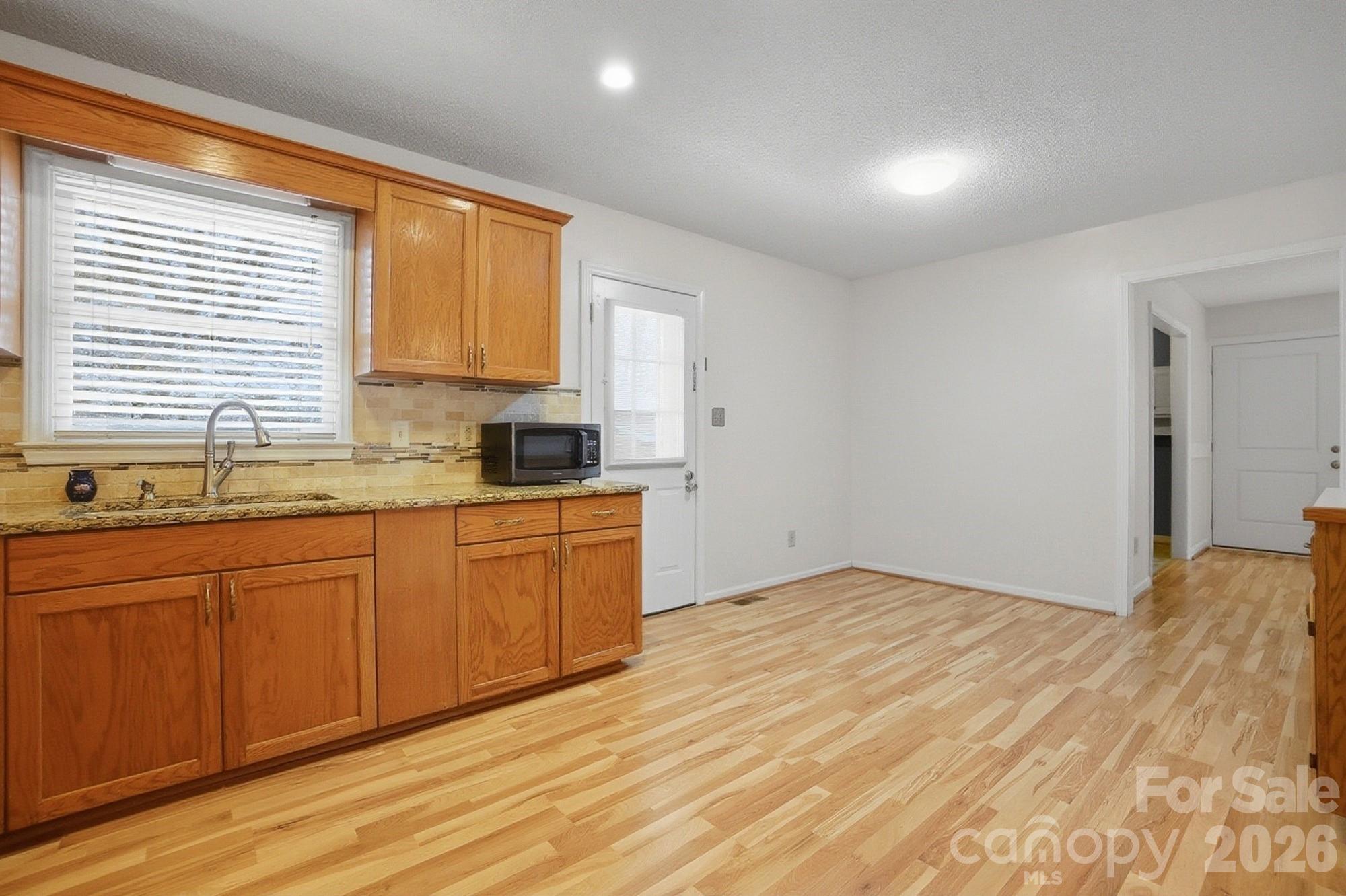 616 Durham Road Stanley, NC 28164 - Photo 11 of 42 a kitchen with granite countertop a sink cabinets and wooden floor