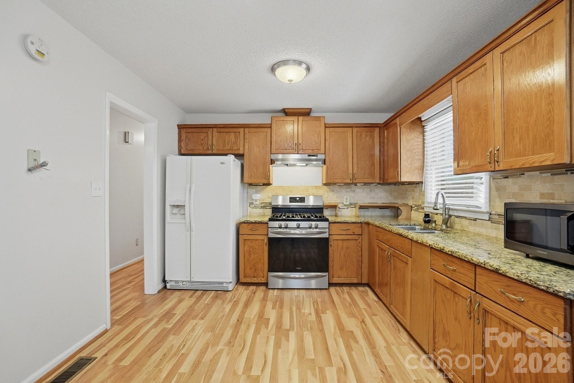 616 Durham Road Stanley, NC 28164 - Photo 8 of 42 a kitchen with granite countertop a refrigerator stove top oven and sink