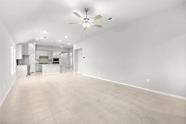 a view of a livingroom with a kitchen counter top space cabinets and stainless steel appliances