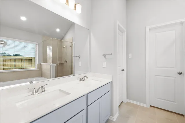 a bathroom with a double vanity sink a mirror and a shower