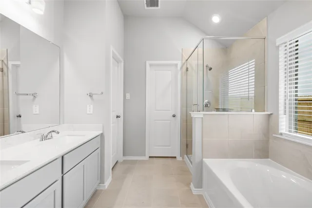 a bathroom with a tub a sink and mirror