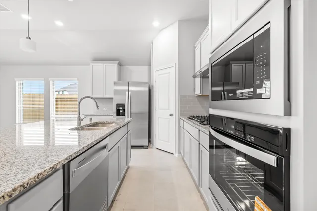 a kitchen with granite countertop stainless steel appliances a stove sink and microwave