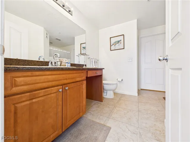 a view of bathroom with a toilet sink and mirror