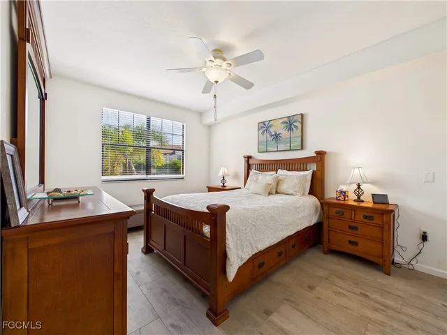 a bedroom with a bed and a dresser next to a window