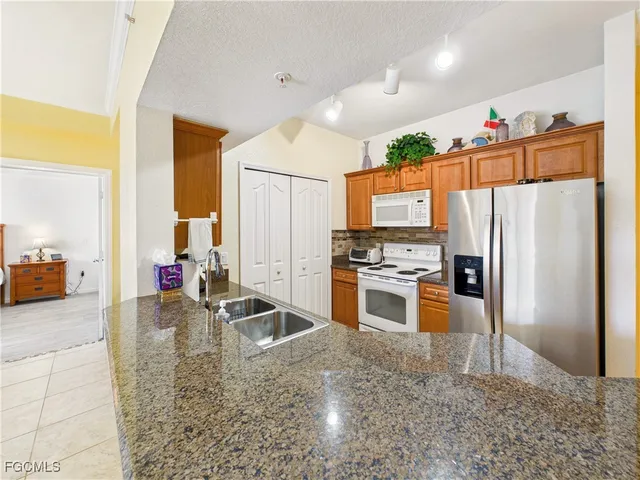 a kitchen with stainless steel appliances granite countertop a refrigerator and a sink