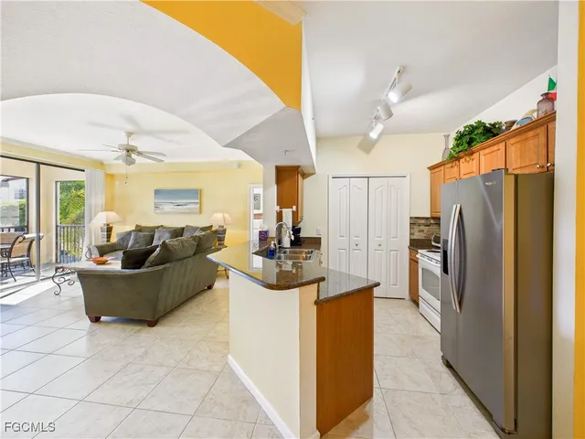 a living room with furniture a large window and stainless steel appliances
