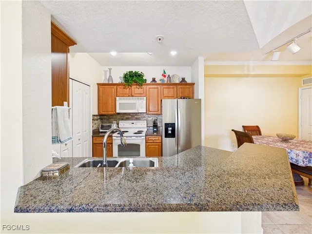 a kitchen with stainless steel appliances kitchen island granite countertop a refrigerator and stove