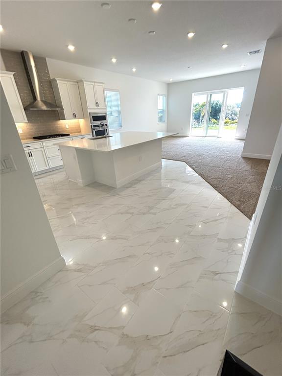 16017 Volterra Point Bella Collina, FL 34756 - Photo 24 of 30 a large kitchen with stainless steel appliances kitchen island granite countertop a large counter top and a stove top oven