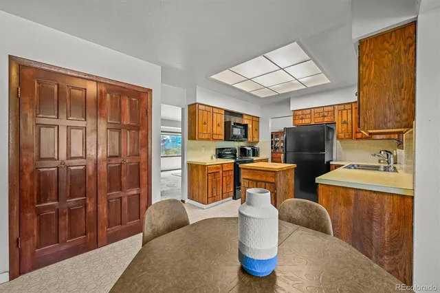 a living room with furniture a flat screen tv and kitchen view