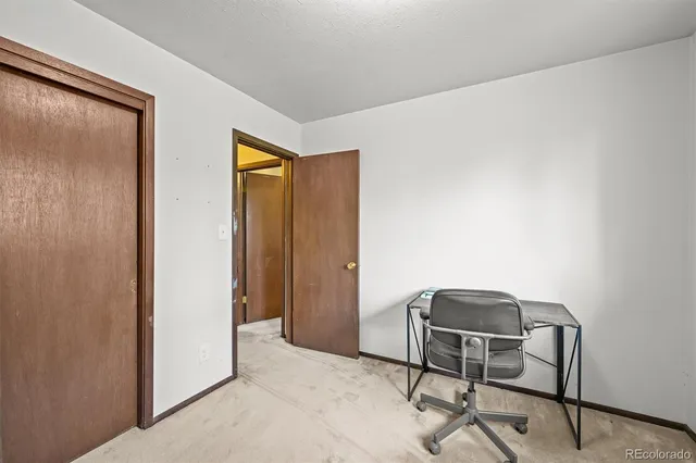 a view of a workspace with furniture and a window