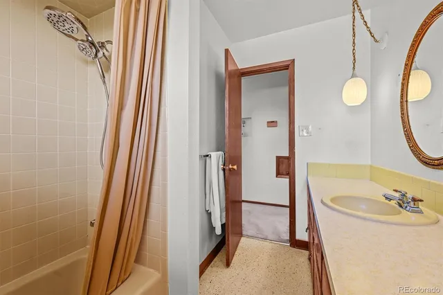 a bathroom with a tub a sink and mirror