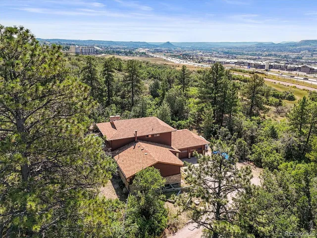 an aerial view of a residential houses with outdoor space and trees