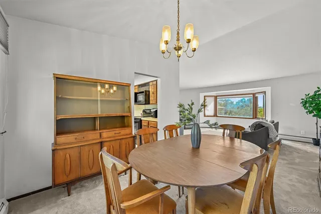 a dining room with furniture a chandelier and window