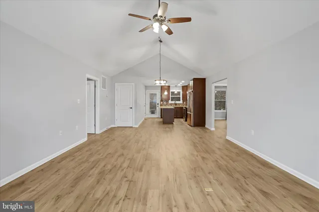a furnished livingroom with a chandelier fan and wooden floor