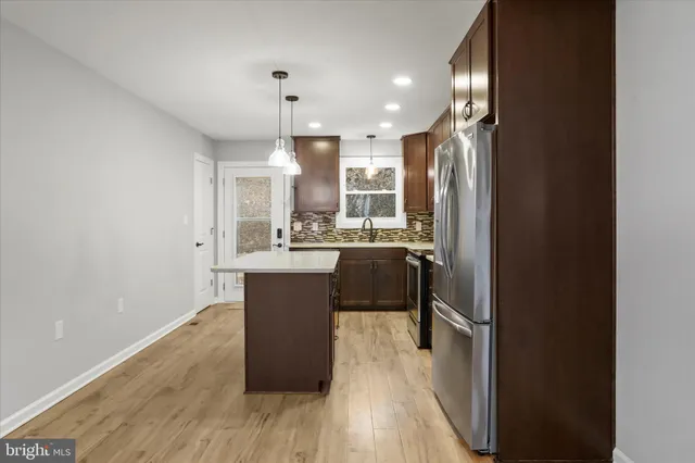 a kitchen with kitchen island a sink appliances and cabinets