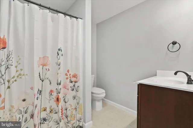 a bathroom with a shower curtain and sink