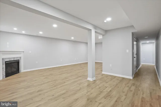 a view of empty room with wooden floor and fireplace
