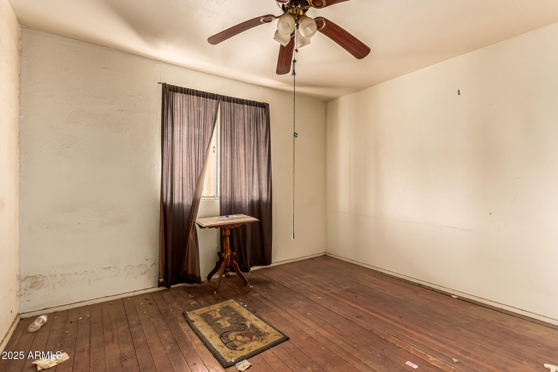 616 West Mobile Lane Phoenix, AZ 85041 - Photo 22 of 29 an empty room with wooden floor fan and windows