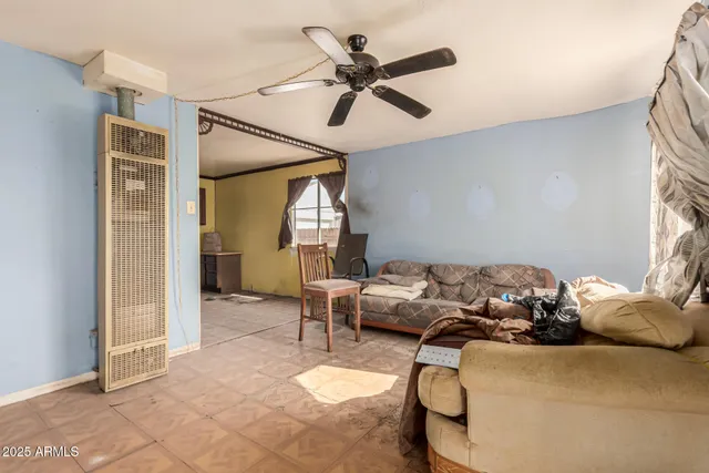 a living room with furniture a ceiling fan and a window
