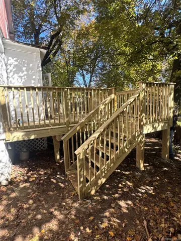 a view of a balcony with wooden floor and fence
