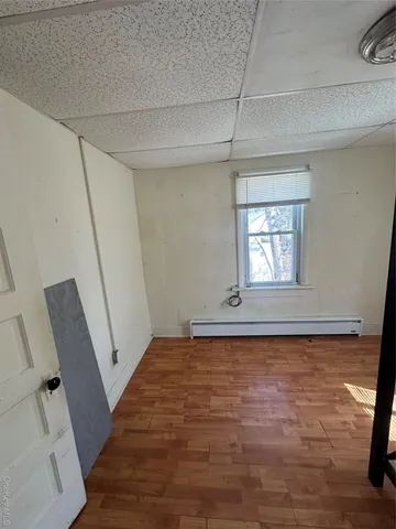 a view of empty room with wooden floor and fan