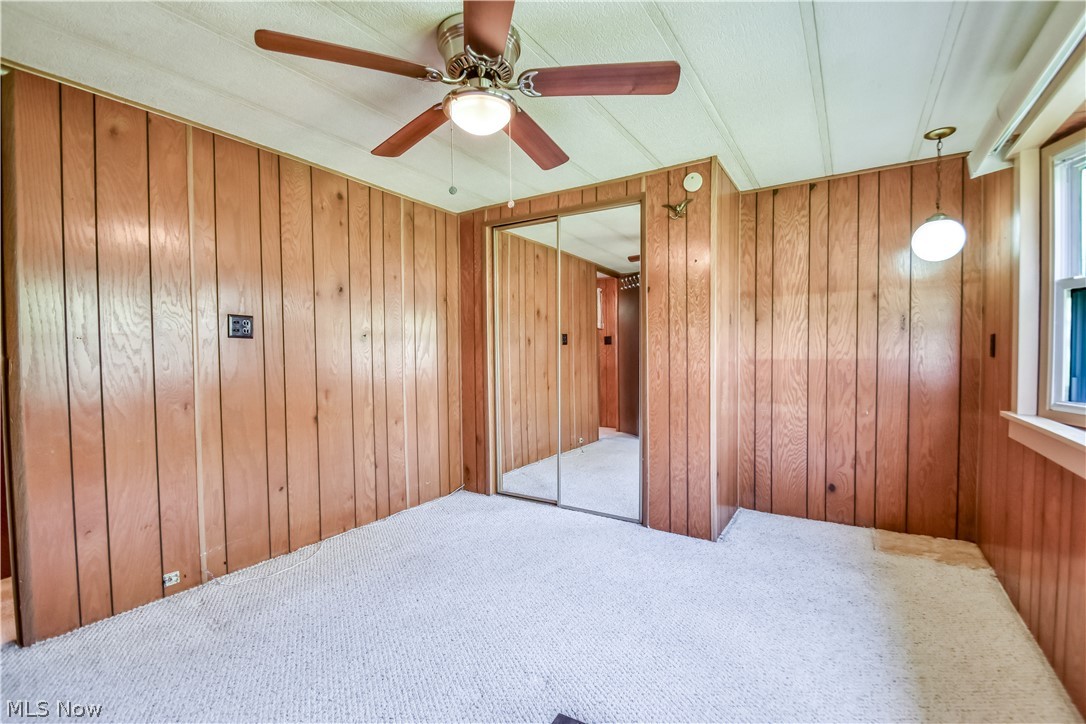 112 Lakeside Way Southwest Warren, OH 44481 - Photo 9 of 16 Room featuring wood-paneled walls, a white textured ceiling, and light-colored carpeting