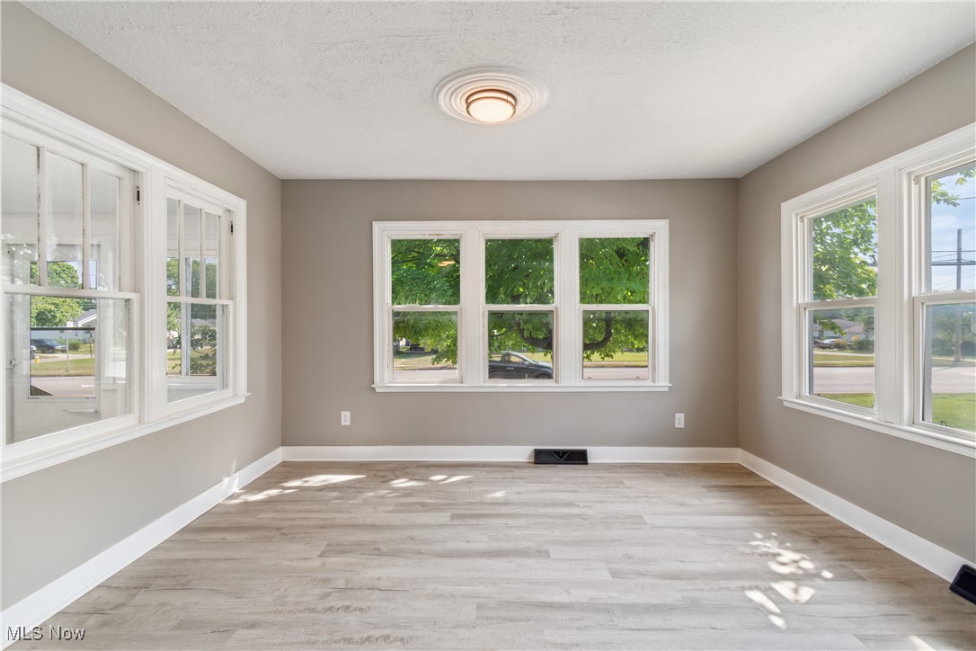 451 West Waterloo Road Akron, OH 44314 - Photo 5 of 27 Empty room with light hardwood / wood-style floors and a wealth of natural light