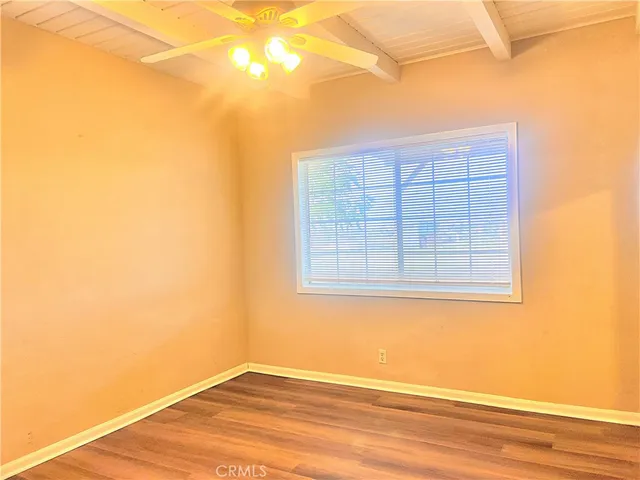 a view of a small space with wooden floor and a window