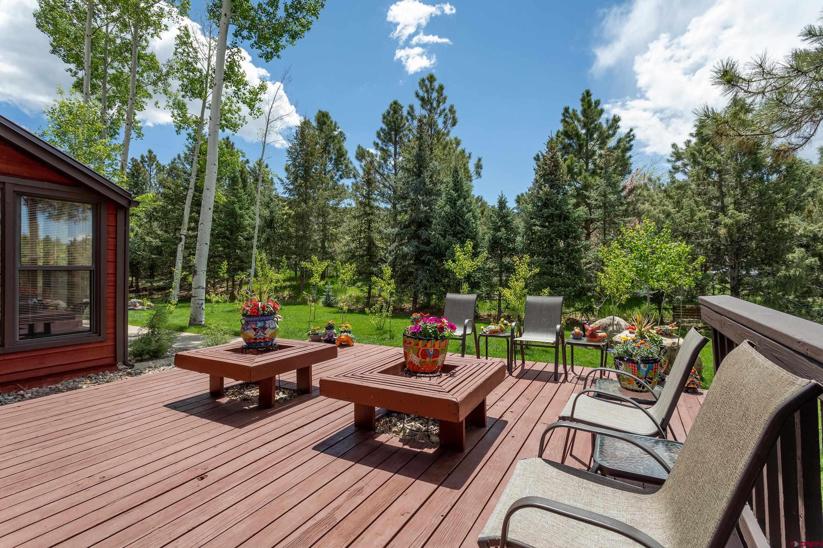 30 Moenkopi Drive Durango, CO 81301 - Photo 27 of 35 a view of a patio with dining table and chairs with wooden floor and fence