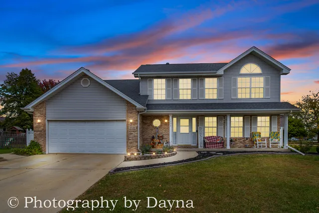 a front view of a house with yard and green space