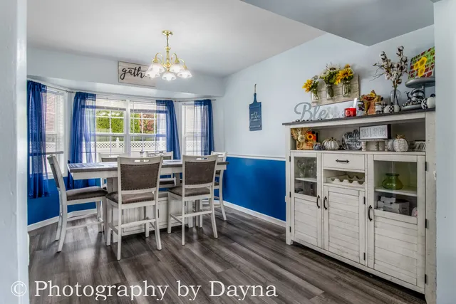 a view of a dining room with furniture a chandelier and wooden floor