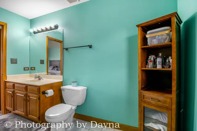 a bathroom with a toilet a sink and mirror