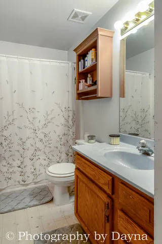 a bathroom with a granite countertop toilet sink and mirror